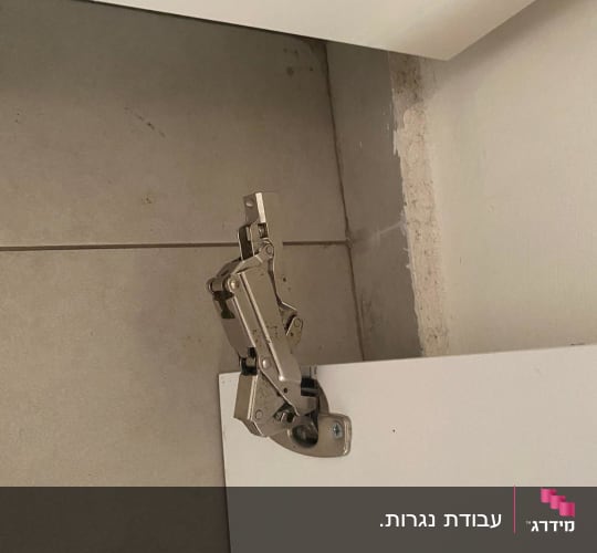 ציר מתכת מחובר לדלת ארון לבנה
